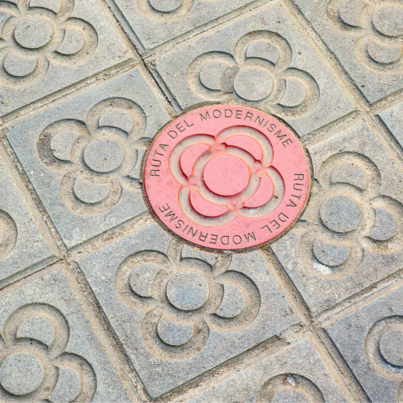Panot de Barcelona con la flor del modernismo en la acera