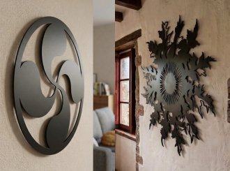 Cuadros Lauburu y Eguzkilore de acero negro mate colgados en la pared de una casa